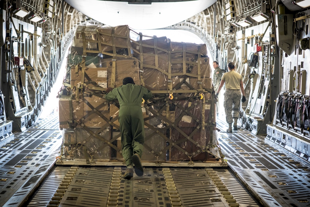 Mission cargo being transferred from a military transport aircraft